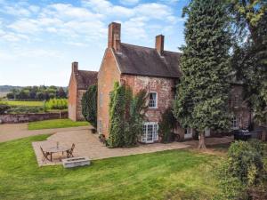 an old brick house with a picnic table in the yard at The Manor Shifnal Telford in Shifnal