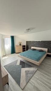 Un dormitorio con una cama grande en una habitación. en La Bubu Apartament 2, en Zărneşti