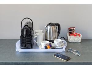 a tray with cups and a coffee pot and glasses at Lea Luxury Rooms in Rome