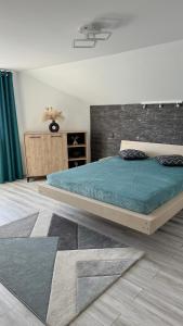 Un dormitorio con una cama grande en una habitación. en La Bubu Apartament 2, en Zărneşti