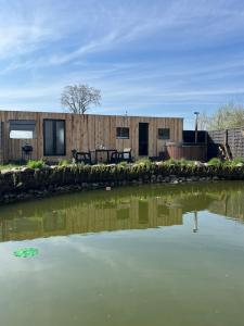 a sustainable house with a pond in front of it at Samosiejka SPA Słońsko in Słońsko
