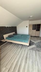 Un dormitorio con una cama en una habitación con suelo de madera. en La Bubu Apartament 2, en Zărneşti