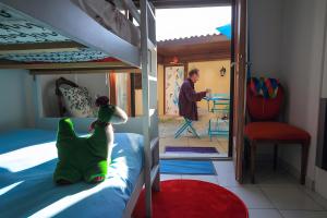 a man standing in a bedroom with bunk beds at Chez Louis in Revel-Tourdan