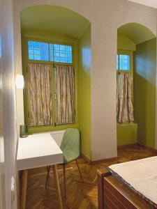 Habitación con 2 ventanas, mesa y silla en Qeto's House, en Tiflis