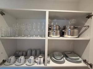 a cabinet filled with glasses and plates and wine glasses at Milis Apartments in Radolfzell am Bodensee