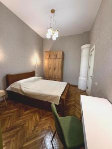 Un dormitorio con una cama y una silla dentro. en Qeto's House, en Tiflis 10 fotos más