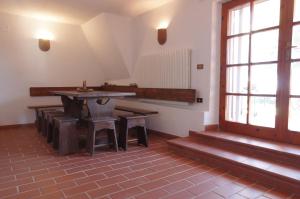 a room with a table and benches and a window at La Casa di Betta in Marcelli