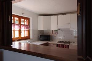 a kitchen with white cabinets and a counter top at La Casa di Betta in Marcelli +10 photos