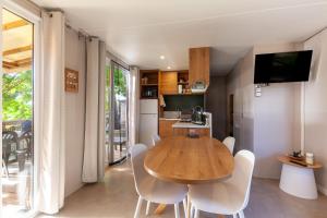 eine Küche und ein Esszimmer mit einem Holztisch und Stühlen in der Unterkunft Camping Lou Soulei 218 in Carry-le-Rouet