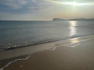 a beach with the sun shining on the water at Eco Crofter's Wagon by the Sea - Off Grid Experience - No electricity - As seen soon on Netflix in Oldshoremore