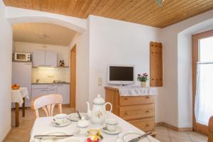 a kitchen and living room with a table and a tv at Nudlbichlerhof in Samerberg