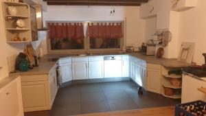 a large kitchen with white cabinets and a window at Luessishausen im Lüsserttal mit 140m2 und DSL in Feilbingert