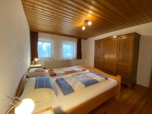 a bedroom with a large bed with a wooden ceiling at Nudlbichlerhof in Samerberg