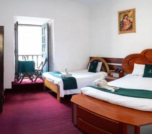 una stanza con due letti e una finestra di Rituales Inn Cusco - San Blas a Cuzco