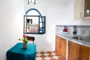una cucina con un tavolo con un vaso di fiori sopra di Rituales Inn Cusco - San Blas a Cuzco