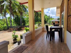 a dining room with a table and a balcony with palm trees at turtles place- Chay's Bungalow in Esperanza +16 photos