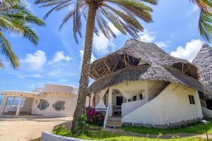 a house on the beach with a palm tree at Ocean View Apartment - Malindi in Malindi