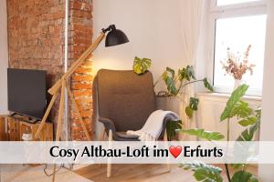 a living room with a chair and a lamp at Helles Altbau-Loft mit Kingsize Bett, Smart-TV, etc in Erfurt