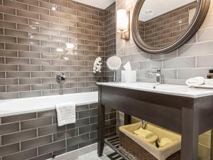 a bathroom with a sink and a mirror at Dakota Leeds in Leeds