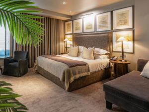 a hotel room with a bed and a chair at Dakota Leeds in Leeds