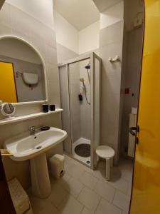 a white bathroom with a shower and a sink at Il posto del cuore in San Feliciano