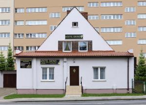 uma casa com um telhado triangular em frente a um edifício em Hostel Grono em Zielona Góra