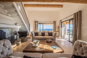 una sala de estar con un sofá y una mesa en Villa Soleil d'Or, golfe de St Tropez, vue mer panoramique, en Cavalaire-sur-Mer