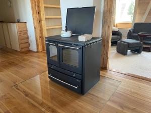 a black microwave sitting in a living room at Großzügige Ferienwohnung nahe Berlin in Nauen