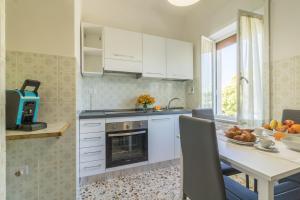 una cucina con mobili bianchi e un tavolo con una fruttiera di Riva Verde a Bolsena