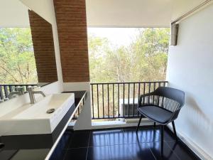 a bathroom with a sink and a chair on a balcony at Nicha at Ayutthaya in Ban Khlong Takhian