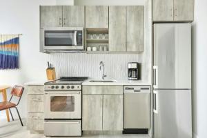 a kitchen with stainless steel appliances and a white refrigerator at Sonder by Marriott Bonvoy Zuni Apartments LoHi in Denver +17 photos