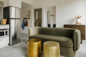 a living room with a couch and two gold stools at The Artesian in Denver +37 photos