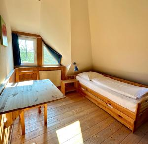 a bedroom with a bed and a table in it at 1000 - Lüntsches Schloss Riepsdorf in Thomsdorf