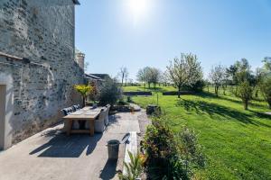 un patio con un tavolo da picnic e un campo erboso di La Maison de la Liberte a Laferté-sur-Amance