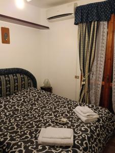 a bedroom with a bed with two towels on it at Villa della Concordia in Plaia Grande