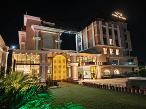 a large building at night with its lights on at Hotel YKM Crown in Dehradun