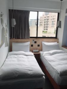 Postel nebo postele na pokoji v ubytování Just Inn Xin Yi 正旅館 信義
