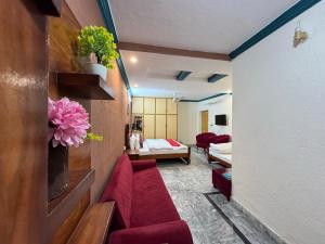 a living room with a red couch and a bedroom at Lexus Lodge in Islamabad