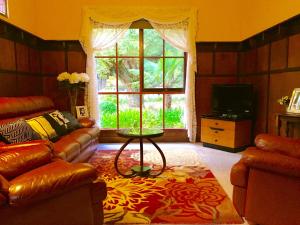 a living room with a couch and a table and a window at Eugenie Cottage 1930s Art Deco in Bright