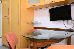 een kamer met een tafel en een tv aan de muur bij SE134 - Marotta, bilocale con balcone e garage in Marotta