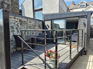 a balcony of a house with a table and flowers at Shilties Pod in Carlingford