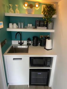a kitchen with a sink and a microwave at Shilties Pod in Carlingford +7 photos