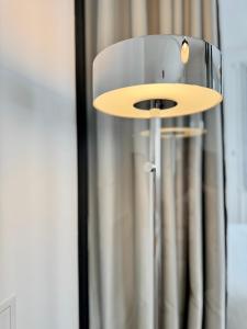 a lamp with a wooden plate on top of it at La Maison Diderot, Centre de Rennes in Rennes