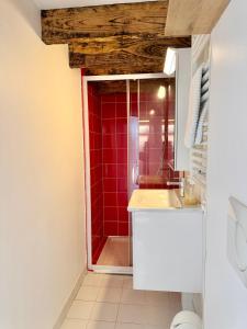 a bathroom with a red shower and a sink at La Maison Diderot, Centre de Rennes in Rennes +30 photos