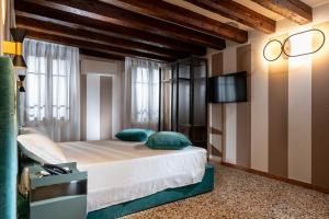a bedroom with a bed and a tv on a wall at Ca' San Geremia in Venice