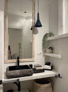 een badkamer met een wastafel en een spiegel bij Loft 1 Beachfront Porto Faro in Palau