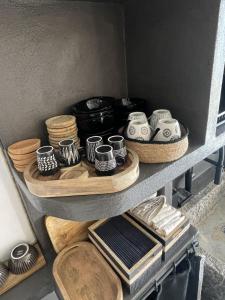 een plank met kommen en andere artikelen erop bij Loft 1 Beachfront Porto Faro in Palau