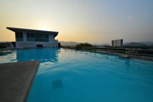 a swimming pool with blue water in front of a building at Modern Thai Suites in Phuket Town