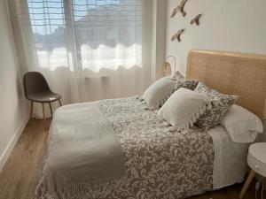 a bedroom with a bed with pillows and a window at Alquiler apartamento playa in Suances +37 photos