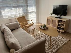 a living room with a couch and a table and a tv at Alquiler apartamento playa in Suances
